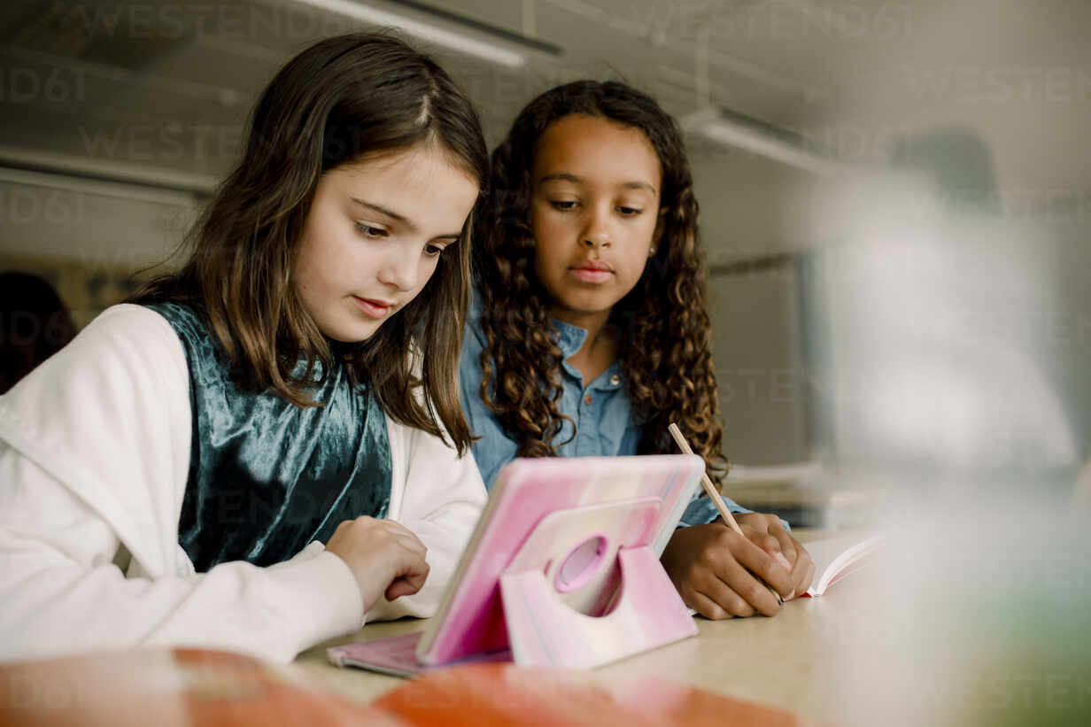 Weibliche Schüler Benutzen Ein Digitales Tablet Am Tisch Im Klassenzimmer Lizenzfreies Stockfoto 