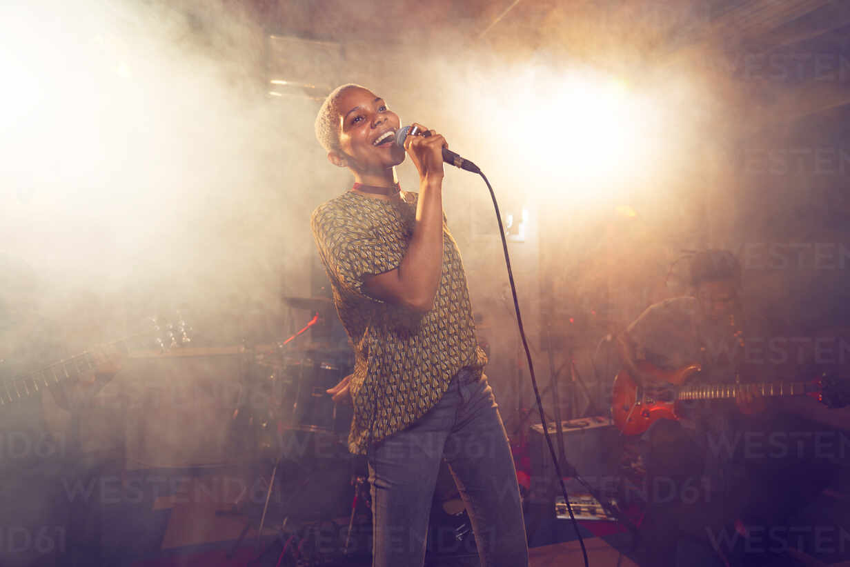 Young female singer performing on stage stock photo