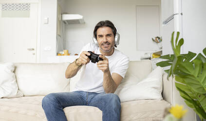 Man disappointed while playing video game with girlfriend at home stock  photo